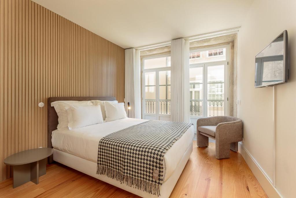 um quarto com uma cama, uma cadeira e uma janela em YOUROPO - Flores no Porto