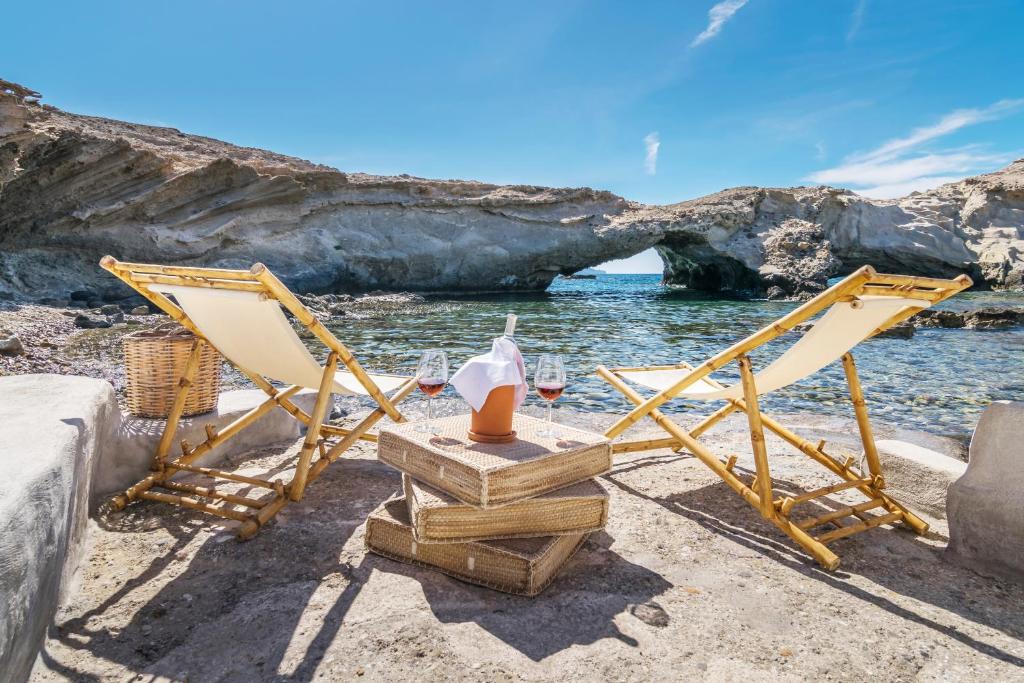 due sedie e un tavolo su una spiaggia con l'oceano di AQUA HOUSE a Pachaina