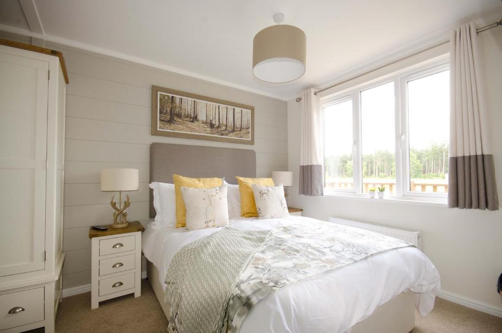 a white bedroom with a bed and a window at Hollicarrs - Woodland Lodge in York