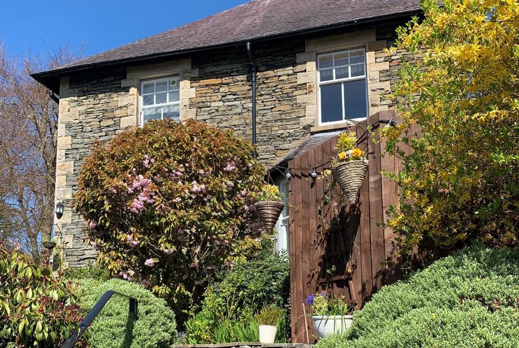 una casa de piedra con una valla delante de ella en Ivythwaite Lodge Guest House en Windermere