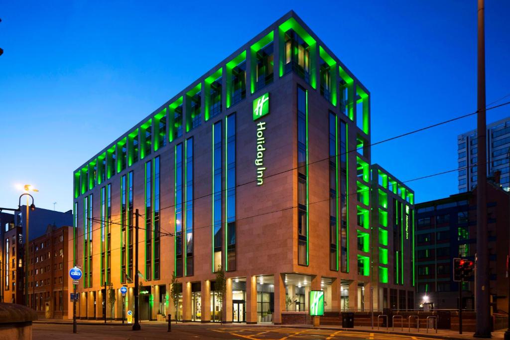 a large building with a clock on the front of it at Holiday Inn Manchester - City Centre, an IHG Hotel in Manchester