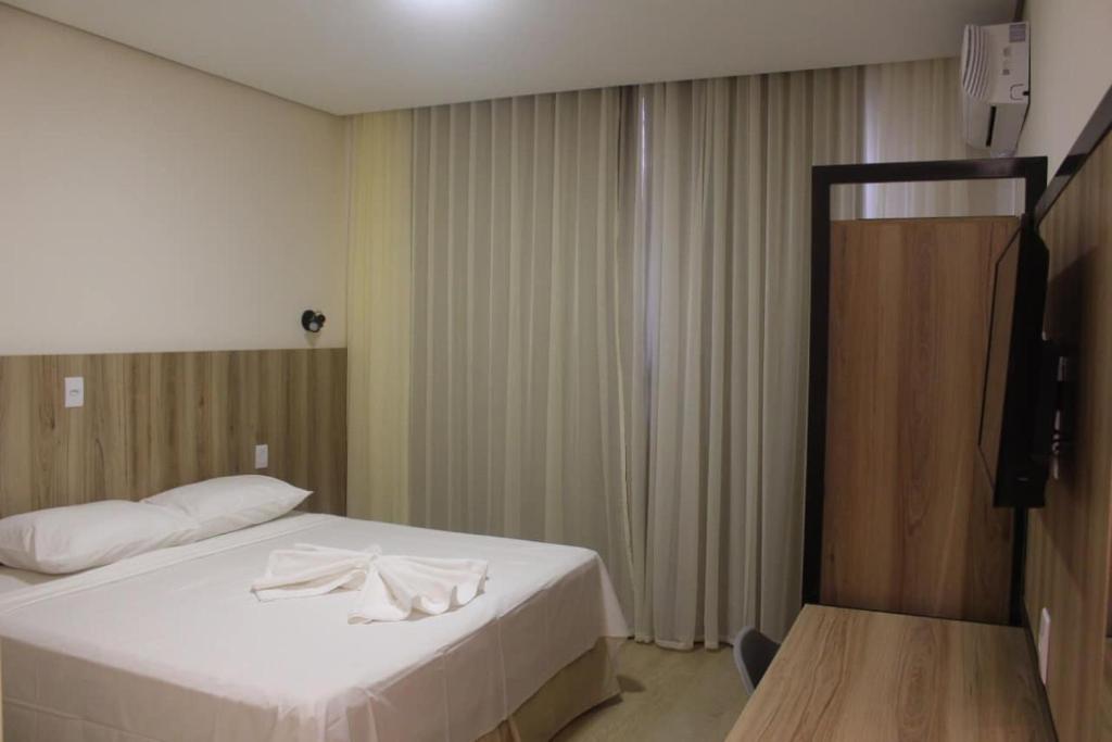 Una habitación de hotel con una cama con toallas. en Hotel Oscar Gold Janaúba, en Janaúba