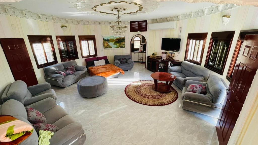 een grote woonkamer met banken en een televisie bij Zohara in Naḥf