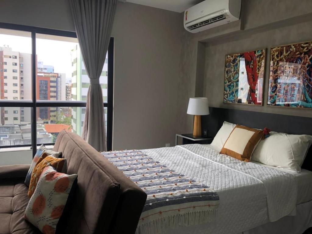 een slaapkamer met een bed en een groot raam bij Edifício Time Apto 724 ER Hospedagens in Maceió