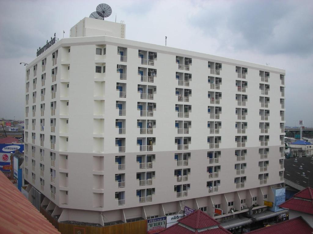 a white building with a clock on top of it at Rangsit Apartment I in Ban Talat Rangsit