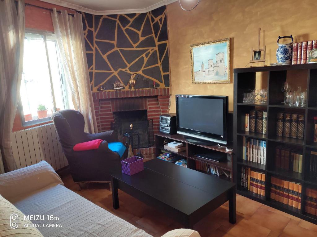 uma sala de estar com uma mesa de centro e uma televisão em Casa de Marta em Carbonero el Mayor