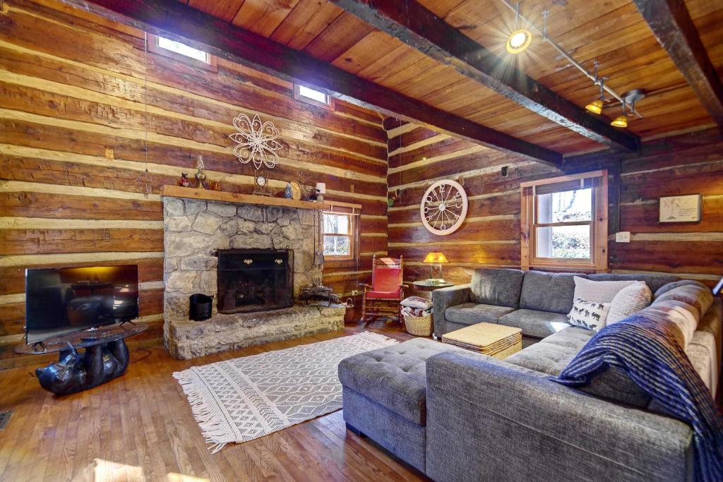 a living room with a couch and a fireplace at Cozy Log Cabin 6 Mi to Great Smoky Mtns NP! in Townsend