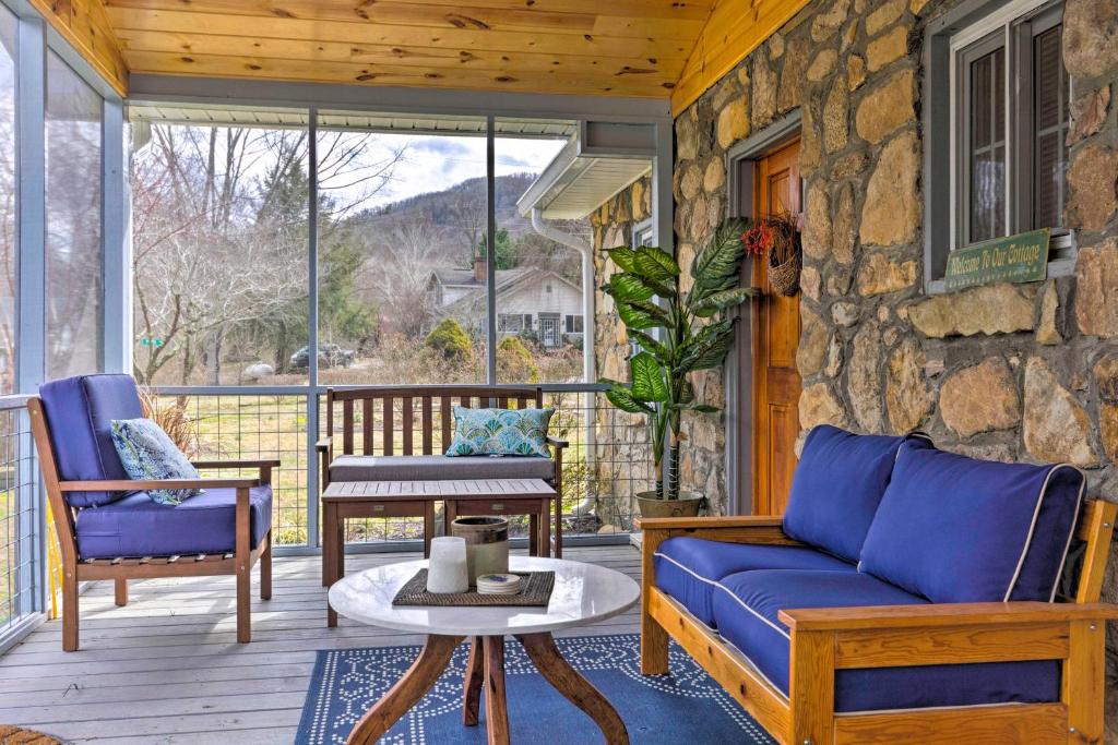 un soggiorno con divano e sedie su un portico di The Rock Cottage Quiet Escape with Porch! a Hot Springs