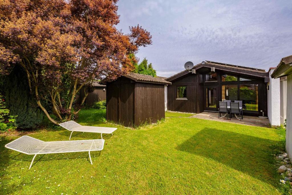 un cortile con panchina e una casa di Ferienwohnpark Immenstaad am Bodensee Satteldachhaus Typ 9 SD 61 a Immenstaad am Bodensee