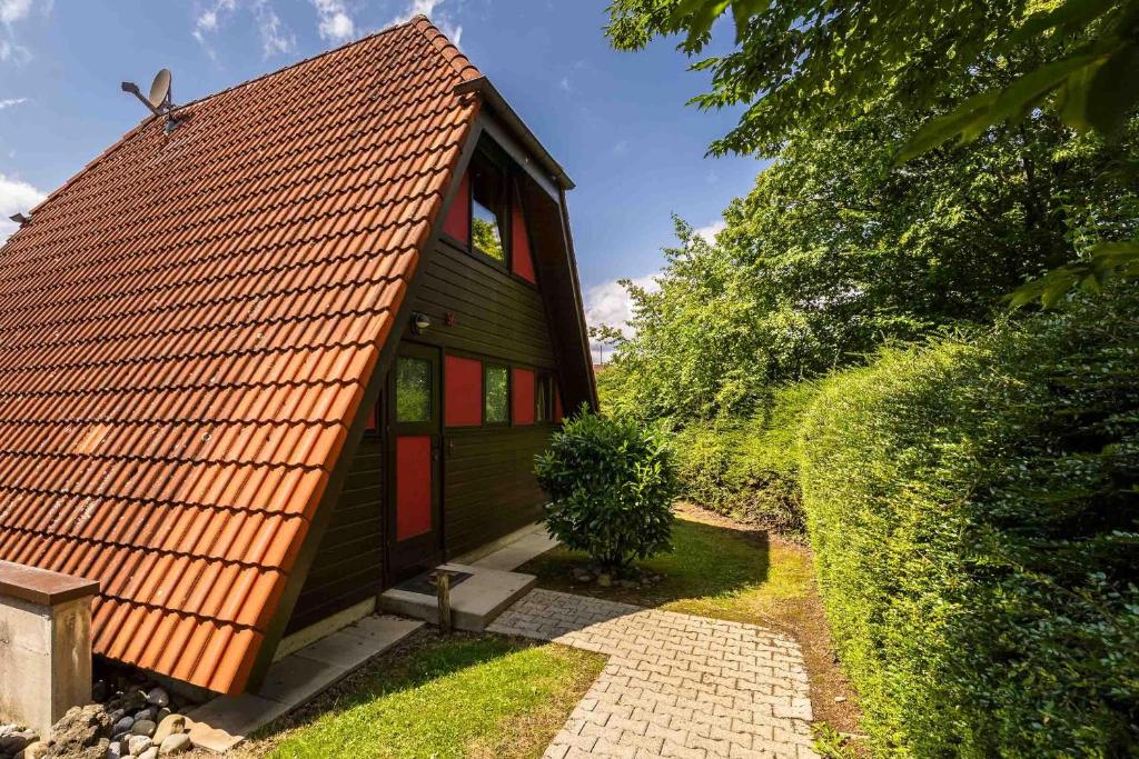 ein kleines grünes Haus mit orangefarbenem Dach in der Unterkunft Ferienwohnpark Immenstaad am Bodensee Nurdachhaus Typ 8 NDT 036 in Immenstaad am Bodensee