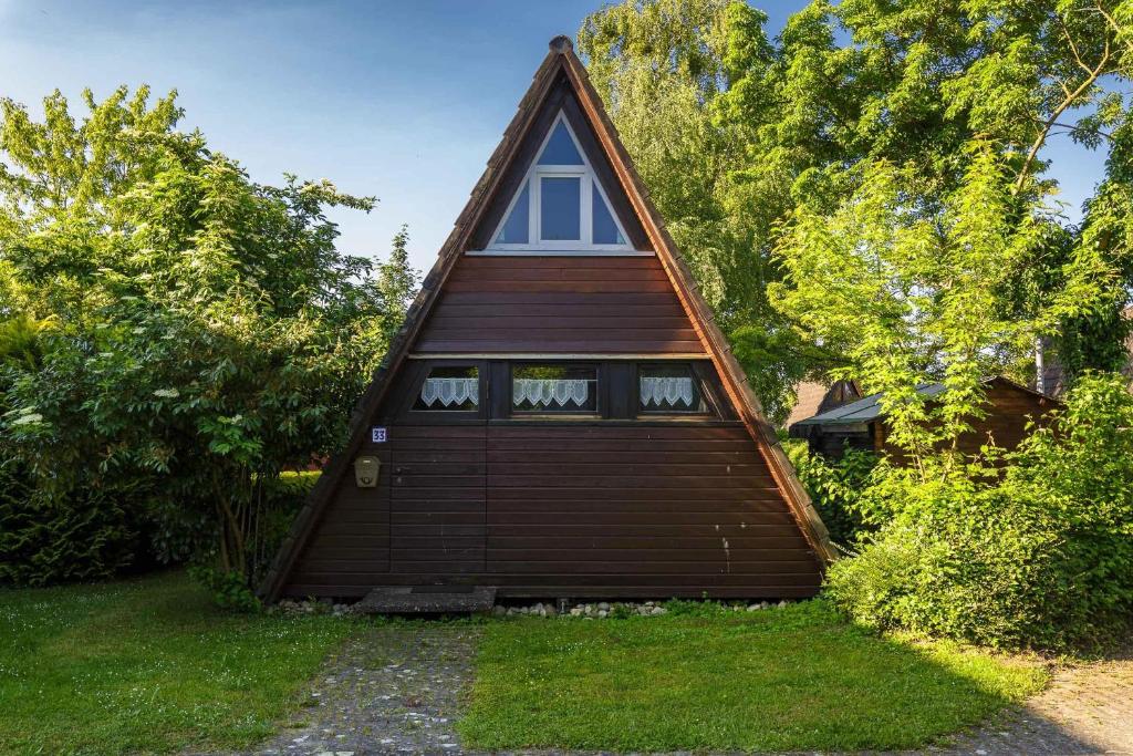 een klein huis met een gambrel dak bij Ferienwohnpark Immenstaad am Bodensee Nurdachhaus Typ 7 ND 33 in Immenstaad am Bodensee