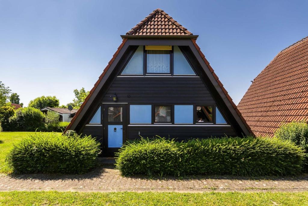 een zwart huis met een gambrel dak bij Ferienwohnpark Immenstaad am Bodensee Nurdachhaus Typ 8 NDT 089 in Immenstaad am Bodensee