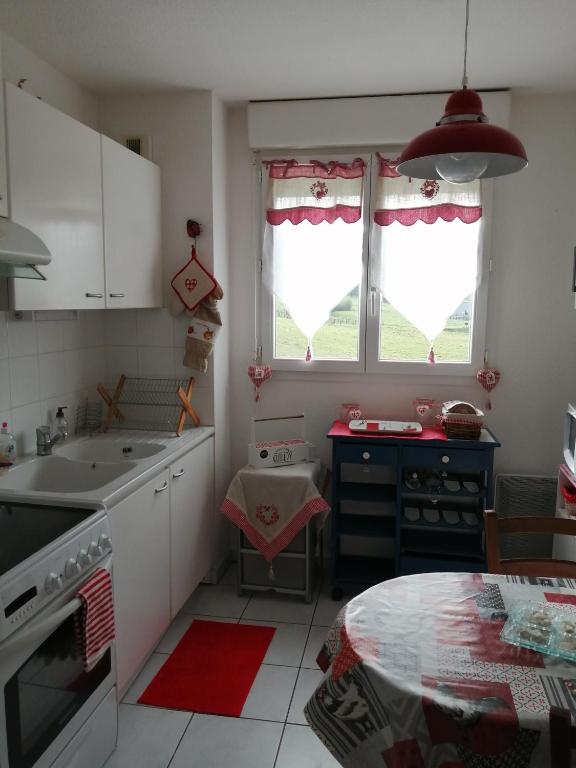 une cuisine avec un évier et une table à l'intérieur dans l'établissement Nid douillet au calme, à Larche