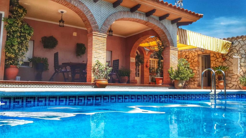 a swimming pool in front of a house at Plaza del Pacifico La Bazana in Jerez de los Caballeros