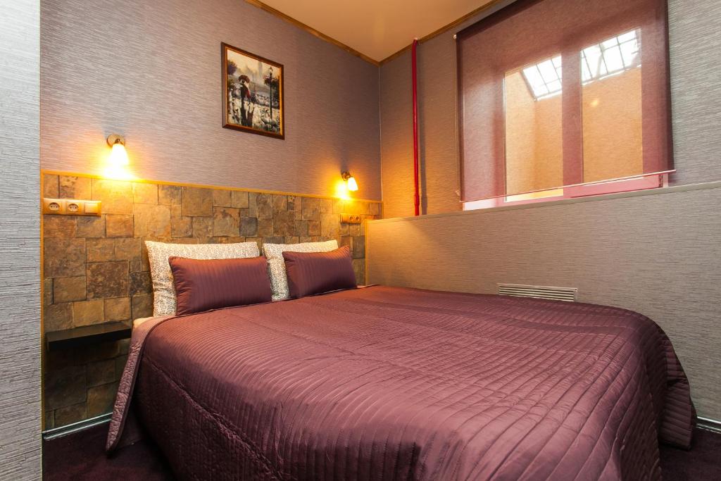モスクワにあるカステッロ ホテルのベッドルーム1室(大きな紫色のベッド1台付)