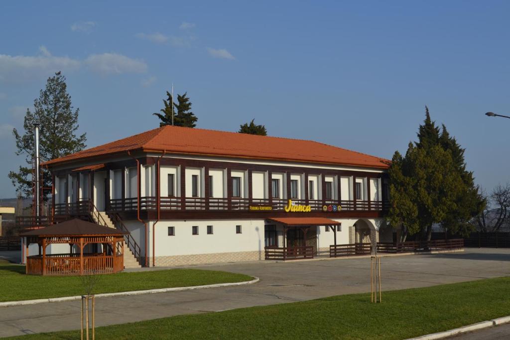 a large white building with a red roof at Jianca Pensiune Agroturistică in Bogea