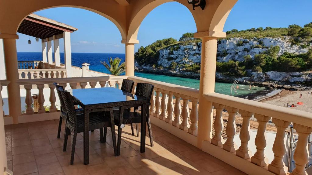 einen Balkon mit einem Tisch, Stühlen und Meerblick in der Unterkunft ROMANTICA Voramar in Cala Romantica