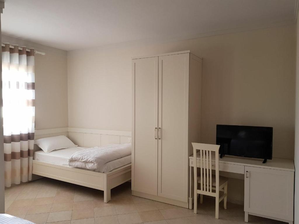 una camera con letto e scrivania con TV di Joel Residence a Durrës