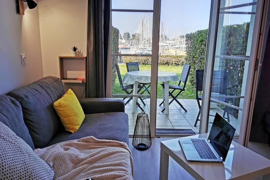 a living room with a couch and a table with a laptop at Vue sur le port de crouesty, tout à pied in Arzon