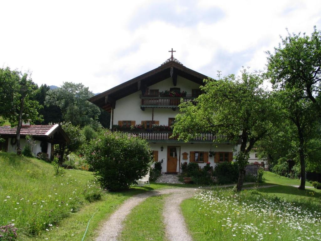 a house on a hill with a dirt road in front at Ferienwohnung Rappl in Schleching
