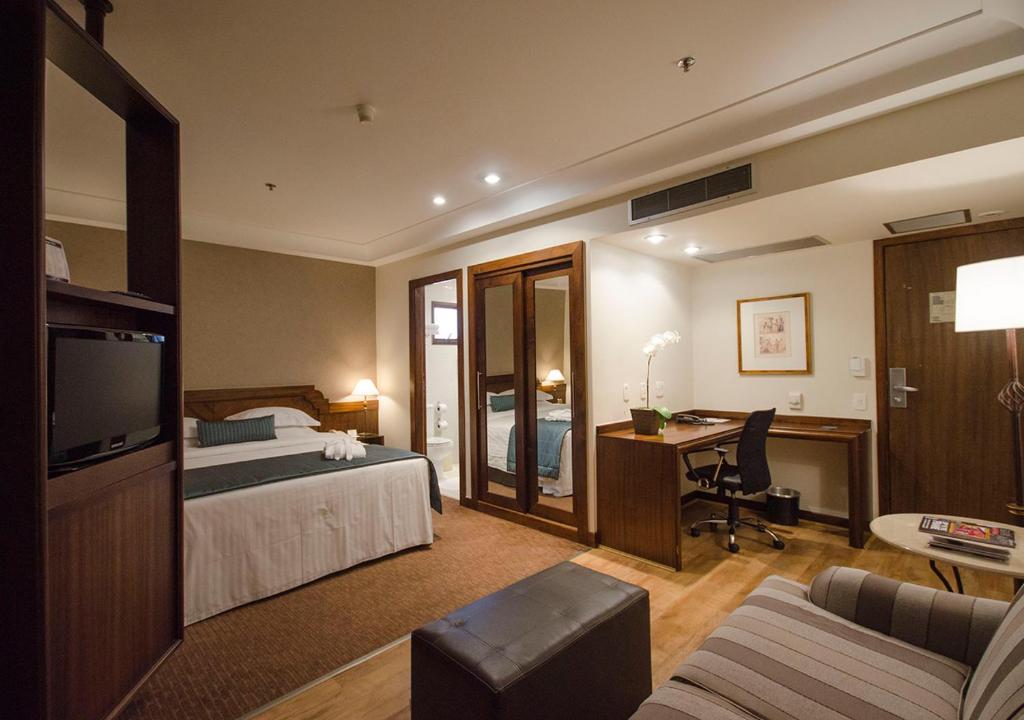 a hotel room with a bed and a desk at Estanplaza Paulista in Sao Paulo