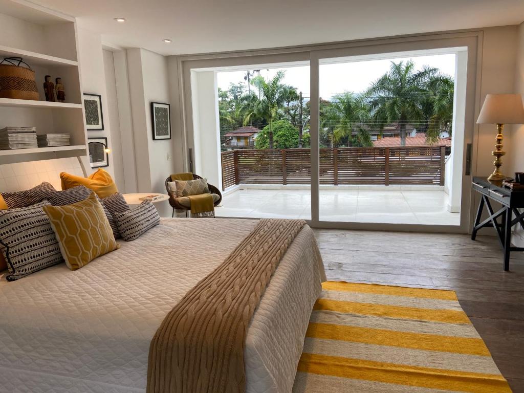 a bedroom with a large bed and a large window at Tropical Contemporary Suites in Paraty