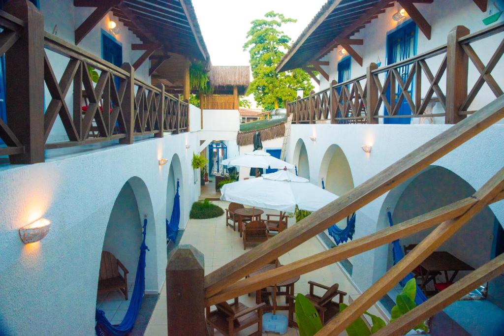 un balcón de un edificio con mesas y sombrillas en Vila Mucugê Pousada e Hostel en Arraial d'Ajuda