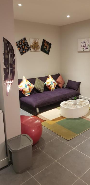 un soggiorno con un divano viola e un tavolo di Bel appart moderne Roanne a Roanne