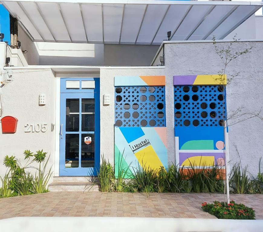 un bâtiment avec une porte bleue et un tableau. dans l'établissement iHOSTEL ALDEOTA, à Fortaleza