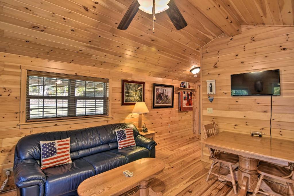 ein Wohnzimmer mit einem Ledersofa in einer Blockhütte in der Unterkunft Cozy Anchors Away Cabin Hideaway with Fire Pit! in Parsons