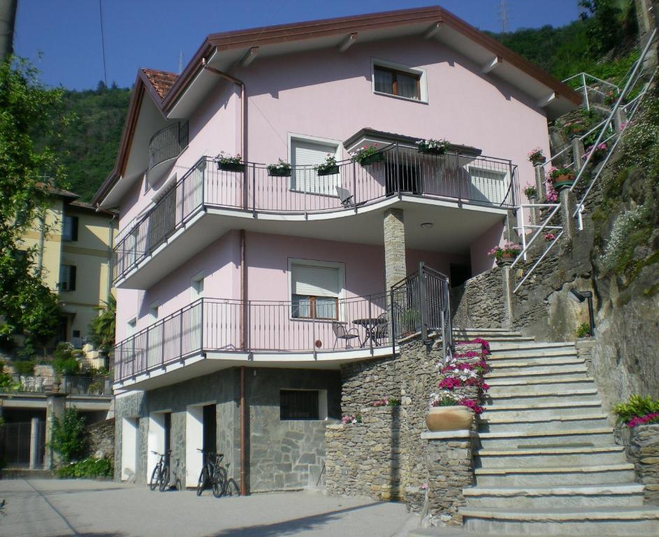 une maison rose avec des escaliers devant elle dans l'établissement Nora Casa Vacanze, à Dervio