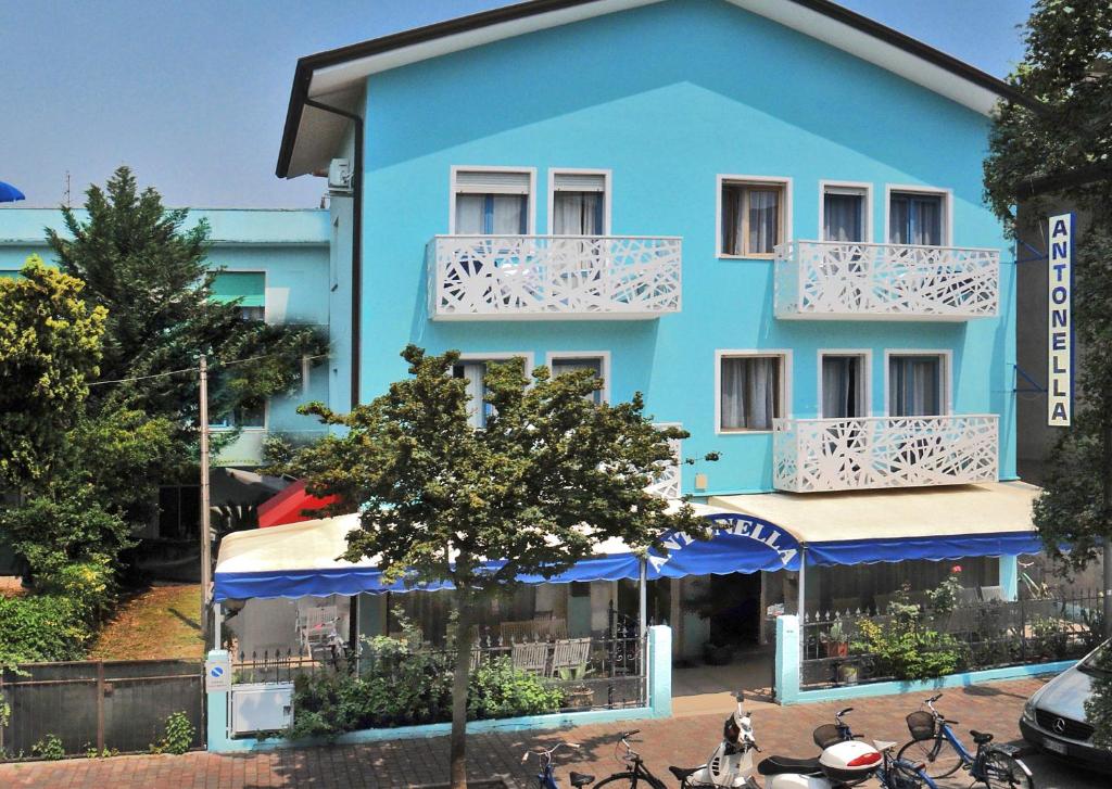 un edificio azul con bicicletas estacionadas frente a él en Hotel Antonella, en Caorle