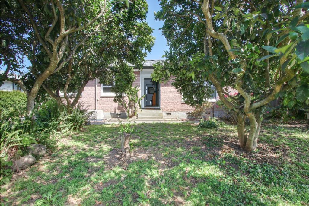 a house with a yard with trees in front of it at Mama and Papa's - Havelock North Holiday Home in Havelock North