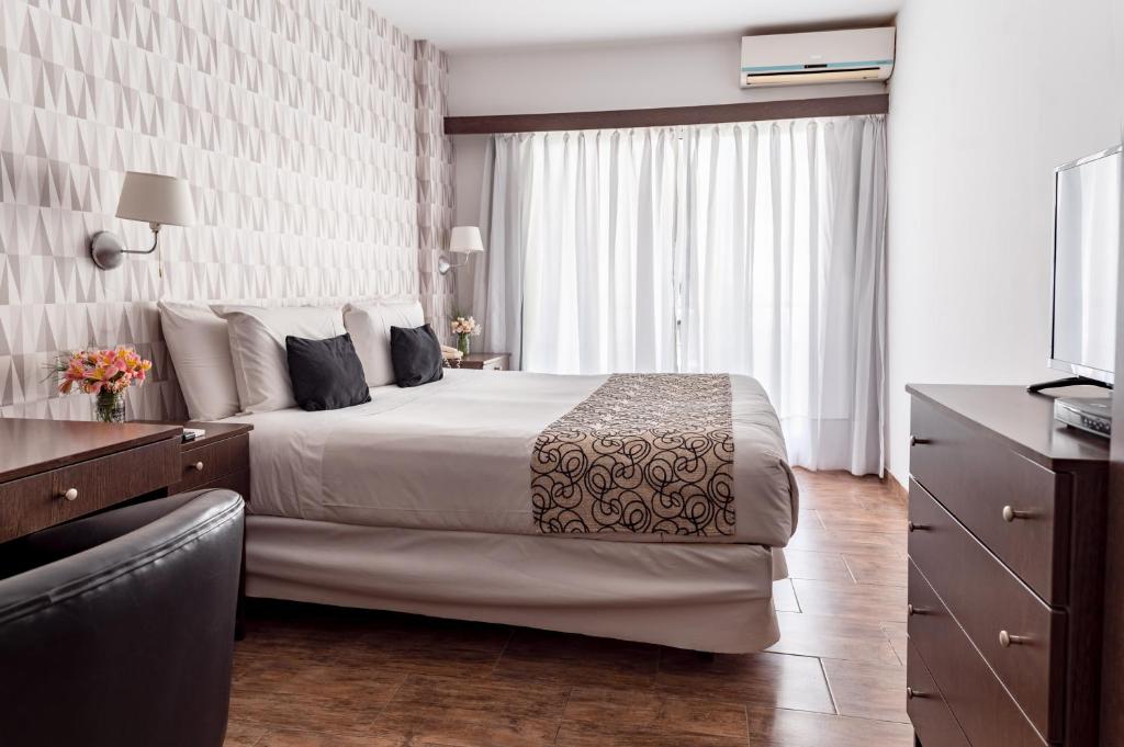 a hotel room with a bed and a television at Ker Belgrano Hotel in Buenos Aires
