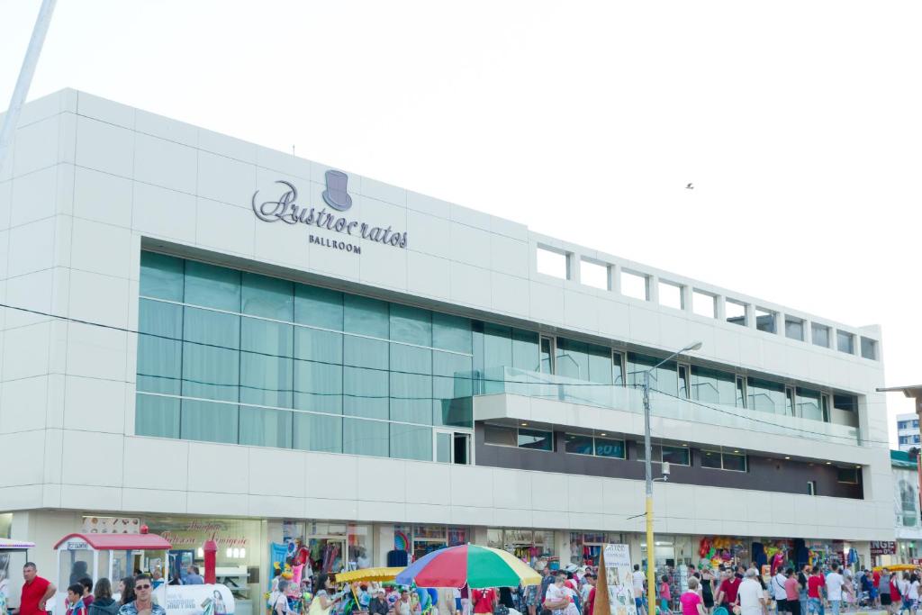 a large building with people standing outside of it at Complex Aristrocratos in Mamaia