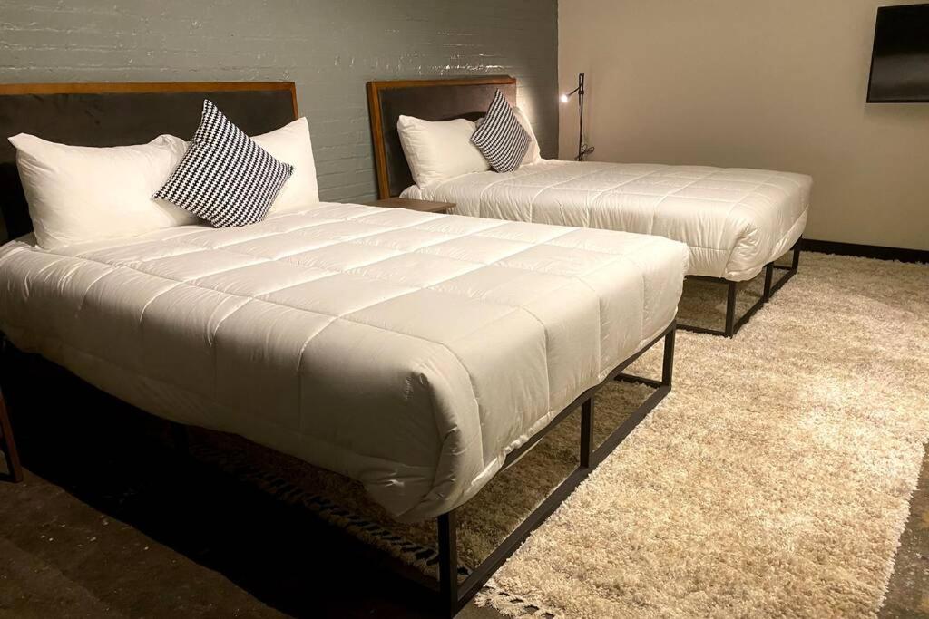two beds in a hotel room with white sheets at 3E-Spacious 2 bedroom in Oakland, sleeps 8 in Pittsburgh