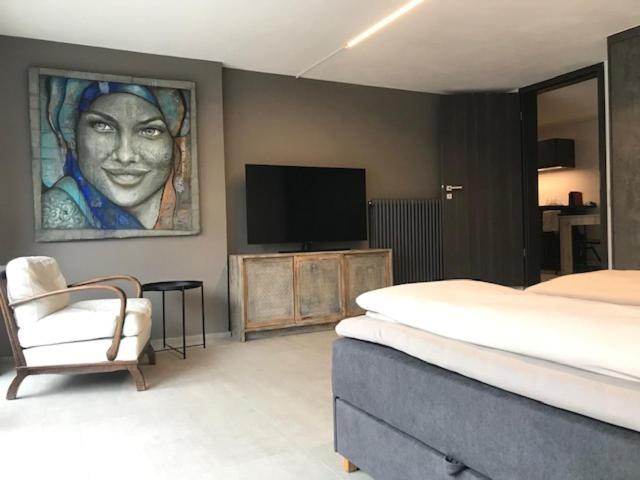 een slaapkamer met een bed, een tv en een stoel bij Blue River in Losone