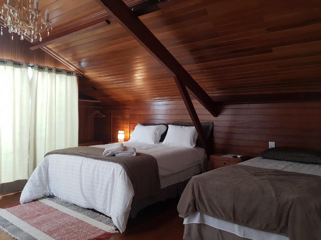 a bedroom with two beds and a wooden ceiling at Suite Tomaz Gonzaga in Ouro Preto