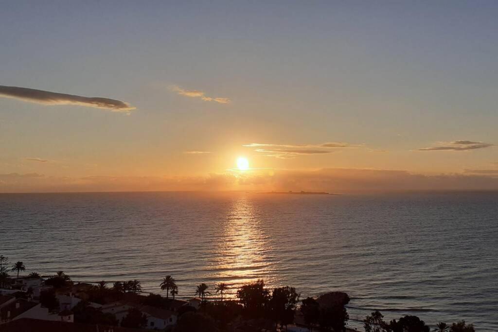 a sunset over the ocean with the sun in the sky at Descansar, sonreír, sentir. Paraíso frente al mar in Santa Pola
