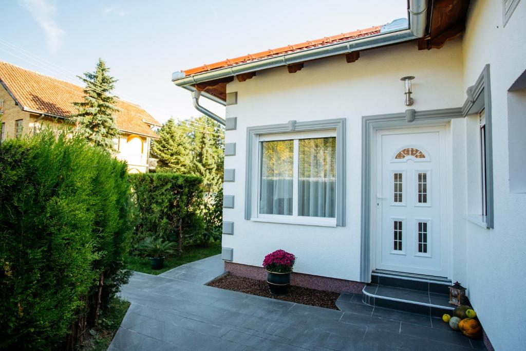 une porte blanche d'une maison avec une fenêtre dans l'établissement Apartmani Mikic, à Palić
