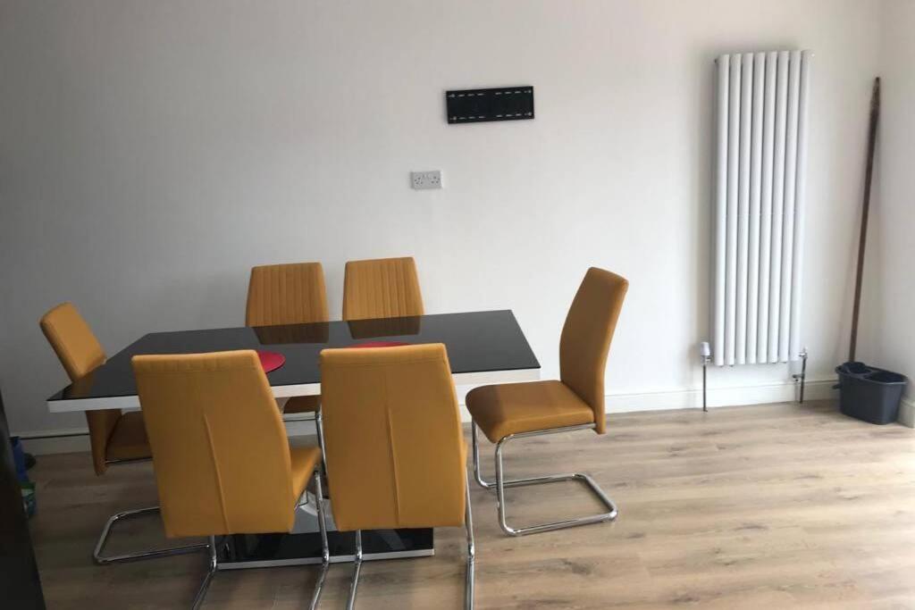 une salle à manger avec une table et des chaises jaunes dans l'établissement The Dartford Five Bedrooms Attractive House, à Kent