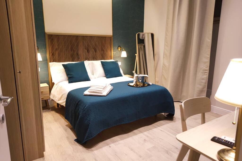 ein Schlafzimmer mit einem Bett mit einer blauen Decke in der Unterkunft D'Annunzio Street Home(Appartamento uso turistico) in Catania