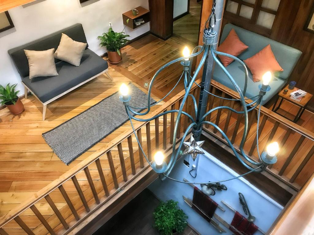 una vista panorámica de una sala de estar con una lámpara de araña en Ñañas Hostel, en Cuenca