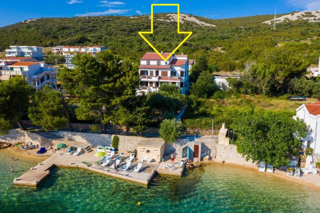 una isla en el agua con una flecha amarilla apuntando a un complejo en Apartments Jadra - 28 m from beach, en Stara Novalja