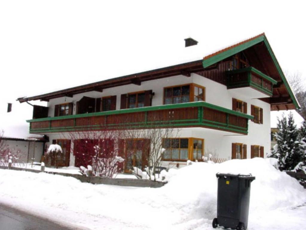 ein Haus im Schnee mit einem Mülleimer davor in der Unterkunft Hammerhaus-Apartment 3 in Siegsdorf