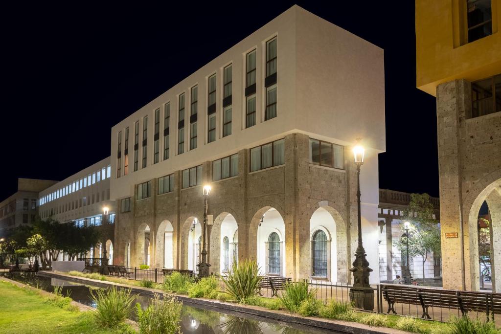 a large building at night with lights on at Six Hotel Guadalajara Degollado in Guadalajara