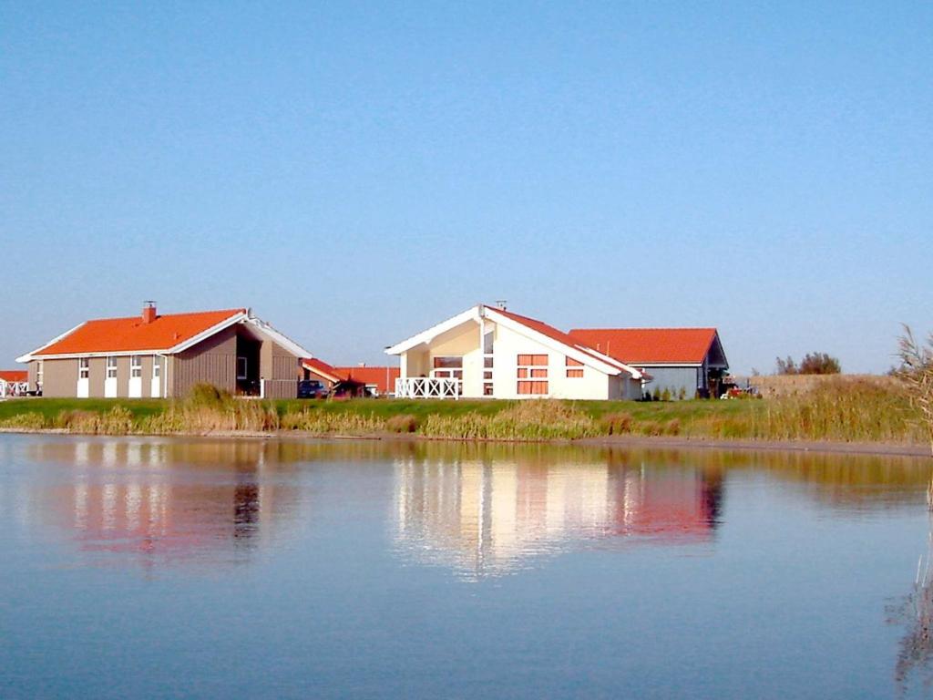 un groupe de bâtiments à côté d'une grande masse d'eau dans l'établissement 12 person holiday home in Otterndorf, à Otterndorf