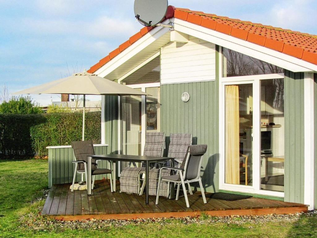 una casa con una mesa y sillas en una terraza en 4 person holiday home in GROEMITZ, en Grömitz