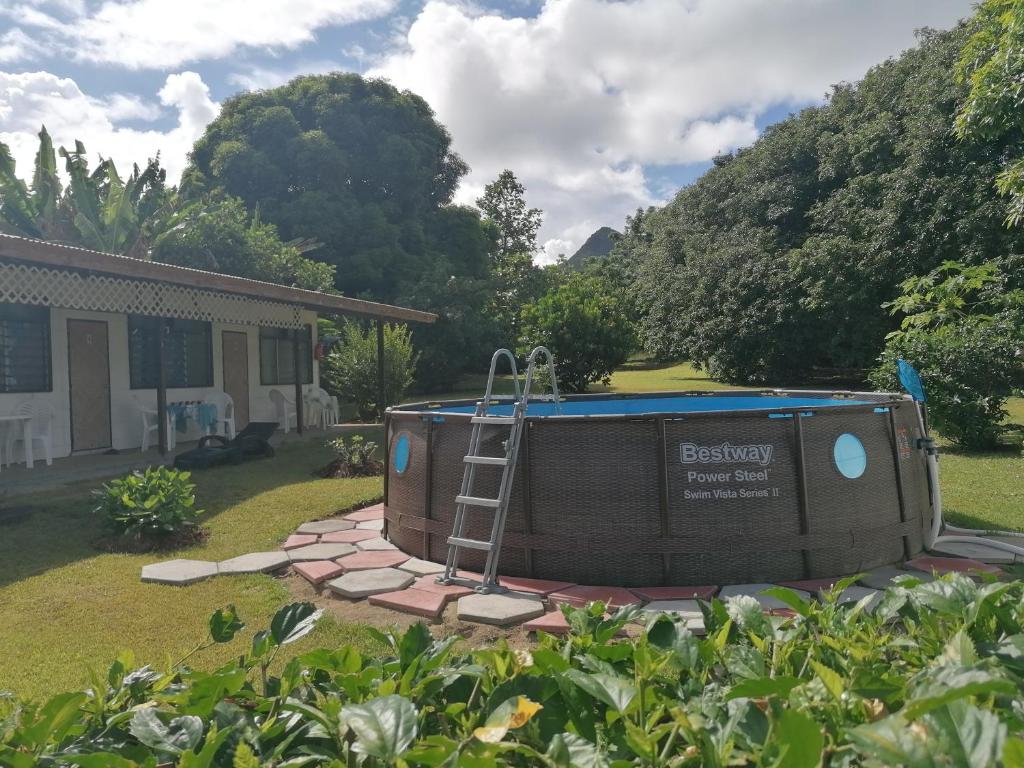 Pension Taitaa Tubuai في توبواي: حوض استحمام ساخن في ساحة بجوار منزل