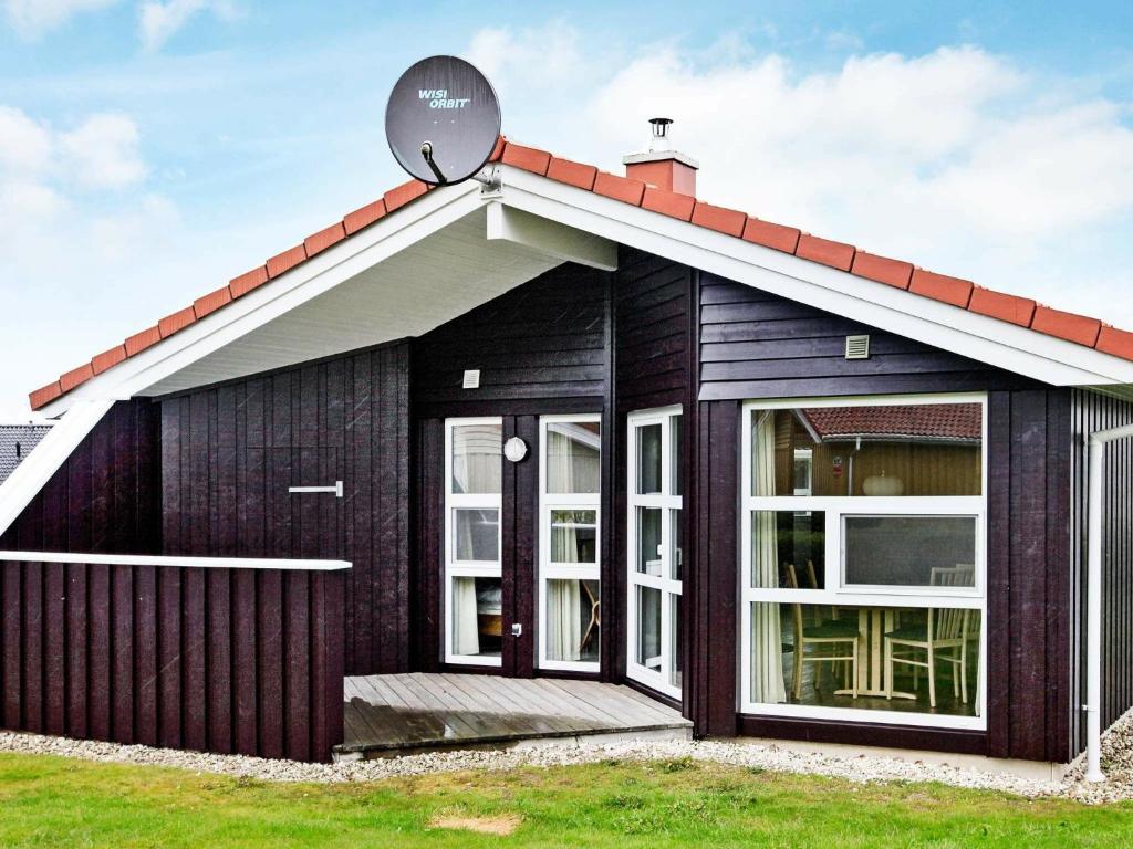 a black house with a red roof at Two-Bedroom Holiday home in Grömitz 3 in Grömitz